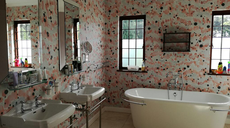 bathroom wallpaper with floral shapes and light colour tones. Wallpaper by Robin Sprong.