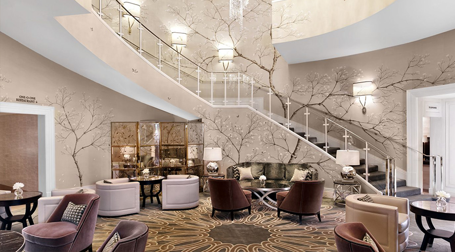 hotel lobby with light wallpaper and illustrations of branches of a tree
