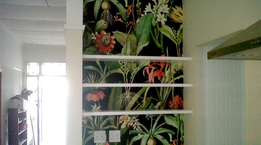 floral illustration behind shelving in kitchen as wallpaper