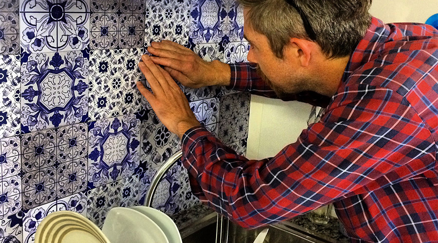 patterned kitchen splashback wall tiles being applied as kitchen wallpaper